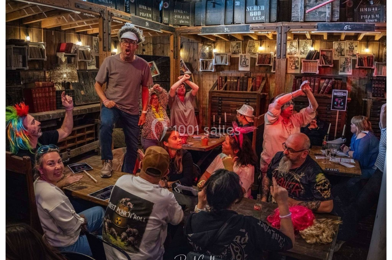 Un groupe de personnes déguisées interagit joyeusement autour de tables dans un décor de bar rustique.