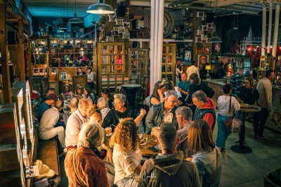 Cinq personnes souriantes posant ensemble derrière un grand cadre doré, devant un fond de rideaux rouges.