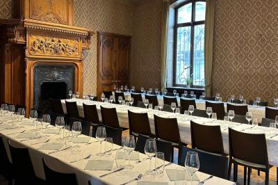 Couloir lumineux avec moquette verte, plantes en pot et portes blanches vitrées au fond.