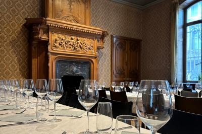 Couloir lumineux avec moquette verte, plantes en pot et portes blanches vitrées au fond.