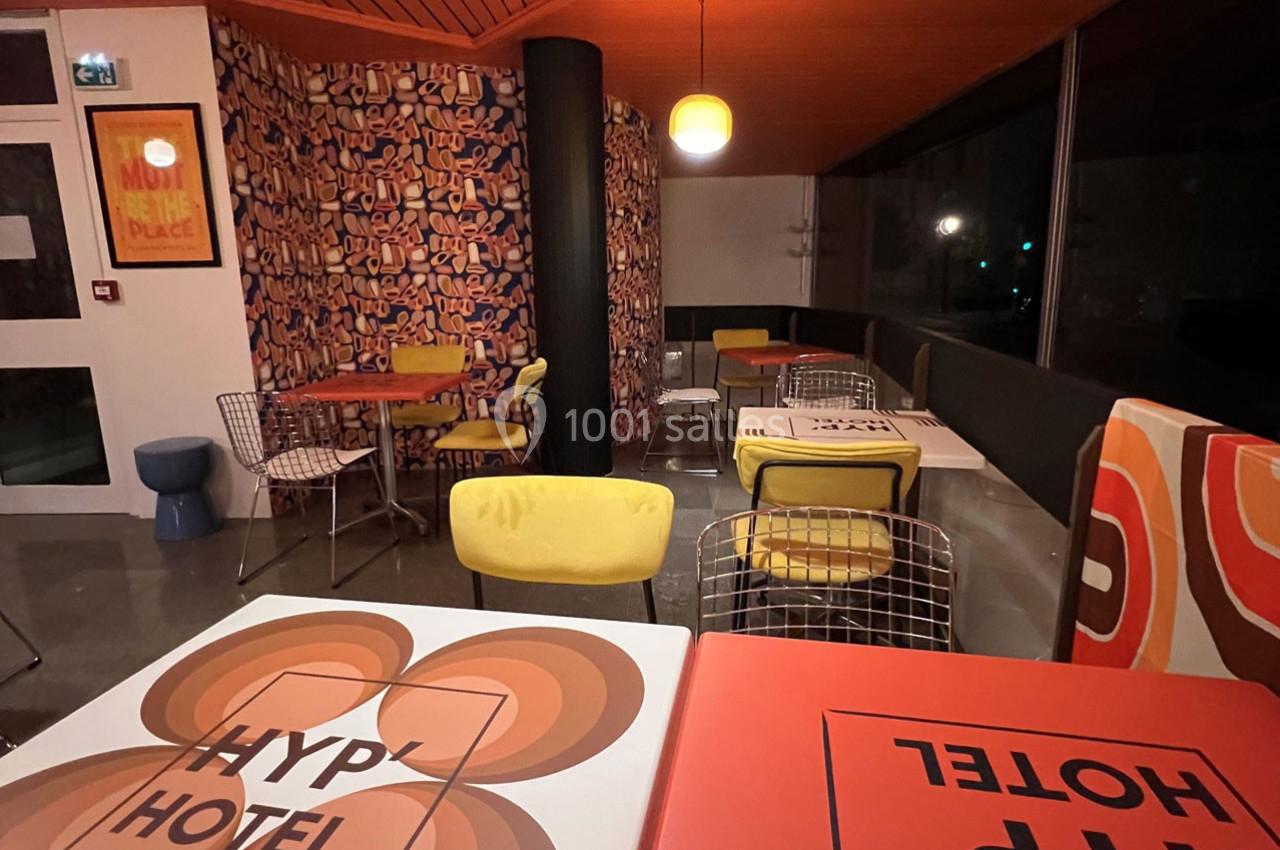 Espace de restauration coloré avec des tables décorées, des chaises modernes et une ambiance rétro.
