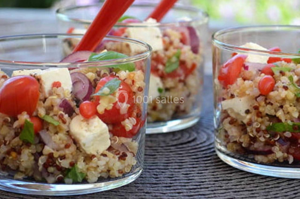 Salade de quinoa servie dans des verrines avec tomates, feta, oignons rouges et herbes fraîches.