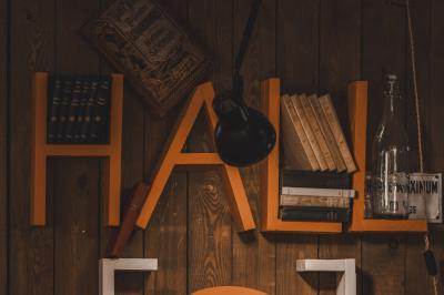 Un chandelier avec des bougies allumées posé près d'une ancienne presse métallique dans un décor artistique.