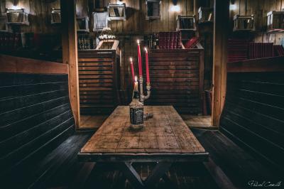 Un chandelier avec des bougies allumées posé près d'une ancienne presse métallique dans un décor artistique.