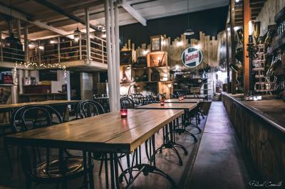 Un chandelier avec des bougies allumées posé près d'une ancienne presse métallique dans un décor artistique.