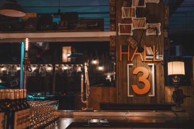 Un chandelier avec des bougies allumées posé près d'une ancienne presse métallique dans un décor artistique.