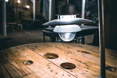 Un chandelier avec des bougies allumées posé près d'une ancienne presse métallique dans un décor artistique.