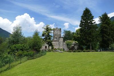 Château en pierre entouré d'arbres et de pelouses bien entretenues, avec un drapeau au sommet de la tour.