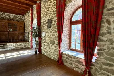Château en pierre entouré d'arbres et de pelouses bien entretenues, avec un drapeau au sommet de la tour.