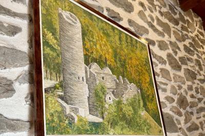 Château en pierre entouré d'arbres et de pelouses bien entretenues, avec un drapeau au sommet de la tour.