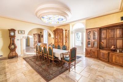 Salle de conférence lumineuse avec rangées de chaises blanches, un pupitre et un micro au premier plan.