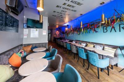 Miniature Location salle Lille (Nord) - O Papa Bar #8 Terrasse vide avec tables et chaises noires sur une rue pavée, devant des façades de cafés et restaurants.