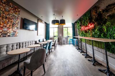 Miniature Location salle Lille (Nord) - O Papa Bar #9 Terrasse vide avec tables et chaises noires sur une rue pavée, devant des façades de cafés et restaurants.