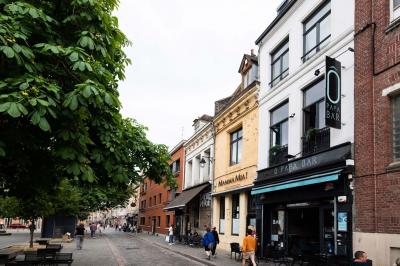 Miniature Location salle Lille (Nord) - O Papa Bar #14 Terrasse vide avec tables et chaises noires sur une rue pavée, devant des façades de cafés et restaurants.