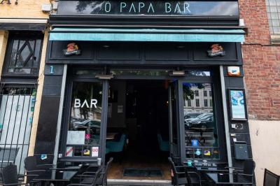 Miniature Location salle Lille (Nord) - O Papa Bar #18 Terrasse vide avec tables et chaises noires sur une rue pavée, devant des façades de cafés et restaurants.