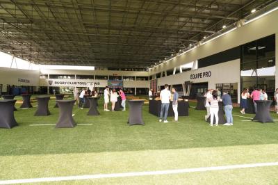 Table ronde en bois entourée de chaises à motifs rouges et blancs, située dans un jardin avec des plantes et des fleurs.