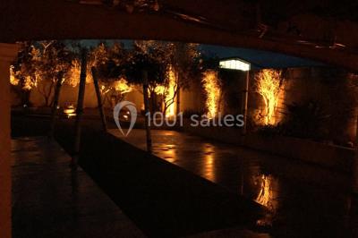 Un couple de mariés danse au centre d'une salle entourée d'invités, avec un sol recouvert de fumée légère.