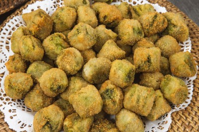 Salle de réception décorée avec des tables rondes dressées, chaises rouges et plafond drapé de voilages lumineux.