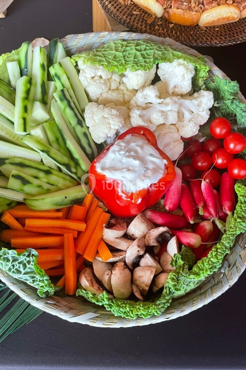 Plateau de crudités variées avec carottes, concombres, tomates cerises, champignons, chou-fleur et sauce dans un poivron…