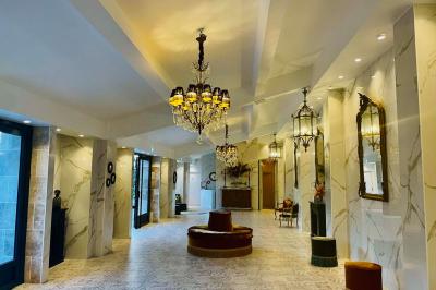 Terrasse extérieure avec tables, chaises, parasol, plantes et vue sur un bâtiment vitré sous un ciel dégagé.