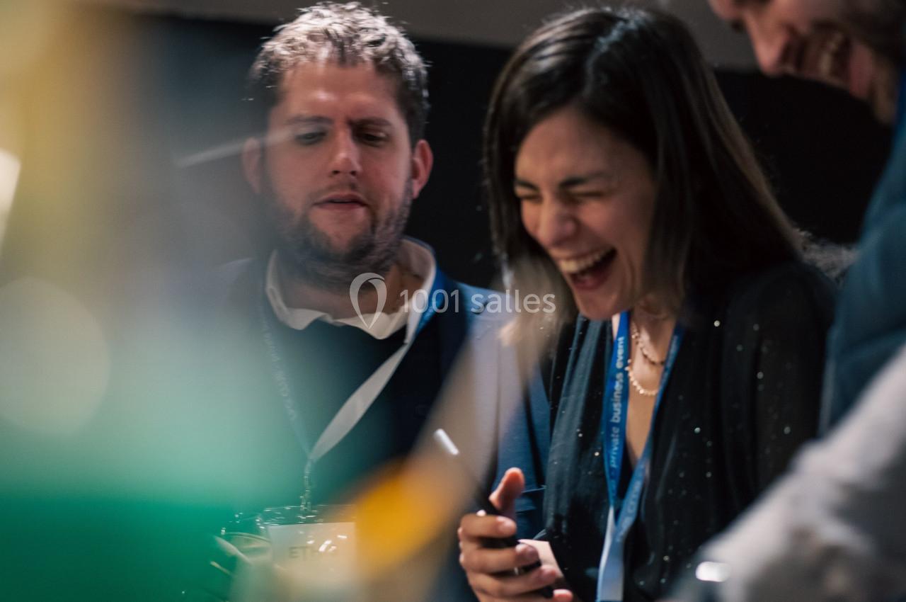 Des personnes souriantes discutent et partagent un moment convivial dans un environnement intérieur.