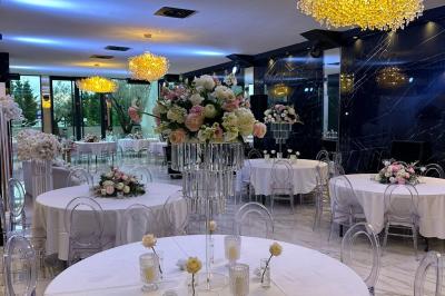 Salon mansardé avec canapé gris, fauteuils, tables d'appoint et éclairage naturel provenant d'une fenêtre inclinée.