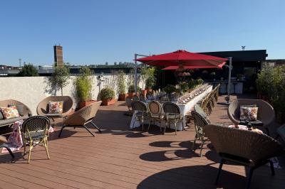 Salon mansardé avec canapé gris, fauteuils, tables d'appoint et éclairage naturel provenant d'une fenêtre inclinée.