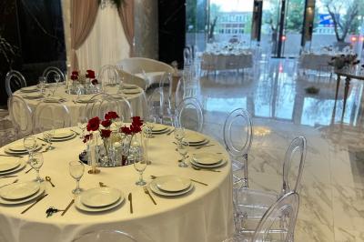 Salon mansardé avec canapé gris, fauteuils, tables d'appoint et éclairage naturel provenant d'une fenêtre inclinée.