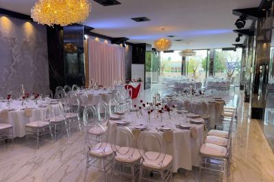 Salon mansardé avec canapé gris, fauteuils, tables d'appoint et éclairage naturel provenant d'une fenêtre inclinée.