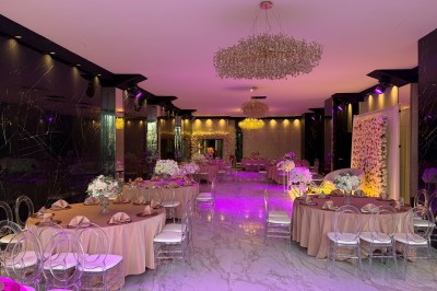 Salon mansardé avec canapé gris, fauteuils, tables d'appoint et éclairage naturel provenant d'une fenêtre inclinée.