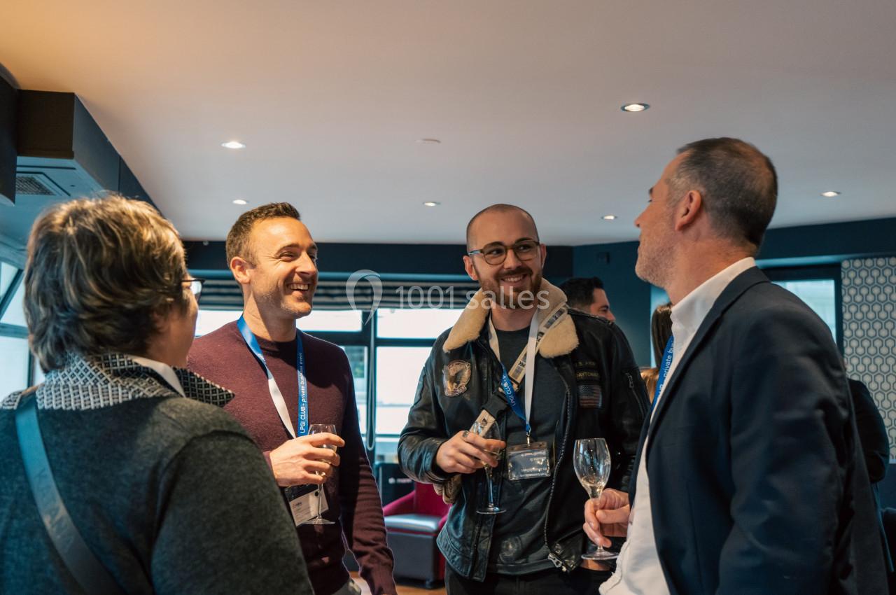 Un groupe de personnes discutant et partageant un moment convivial dans un espace intérieur.