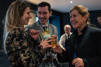 Des personnes trinquent avec des cocktails colorés dans un cadre convivial.