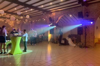 Miniature Show Spectacle #31 Façade d'un bâtiment en briques avec grandes fenêtres, porte ouverte et équipements audio installés à l'extérieur.