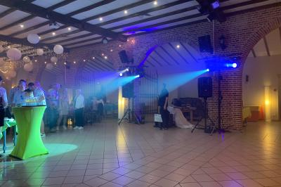 Miniature Show Spectacle #23 Façade d'un bâtiment en briques avec grandes fenêtres, porte ouverte et équipements audio installés à l'extérieur.