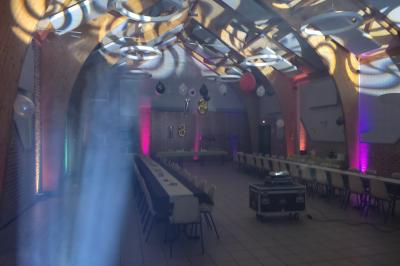 Miniature Show Spectacle #38 Façade d'un bâtiment en briques avec grandes fenêtres, porte ouverte et équipements audio installés à l'extérieur.