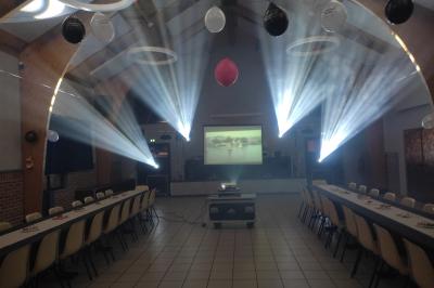 Miniature Show Spectacle #25 Façade d'un bâtiment en briques avec grandes fenêtres, porte ouverte et équipements audio installés à l'extérieur.