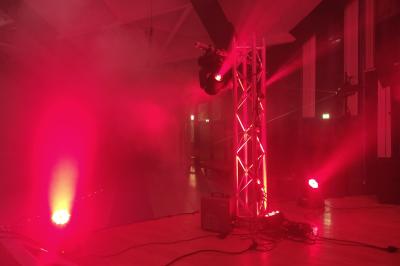 Miniature Show Spectacle #41 Façade d'un bâtiment en briques avec grandes fenêtres, porte ouverte et équipements audio installés à l'extérieur.