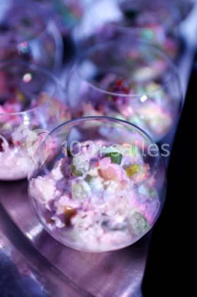 Dessert coloré servi dans des verrines transparentes, présenté sur une surface métallique.