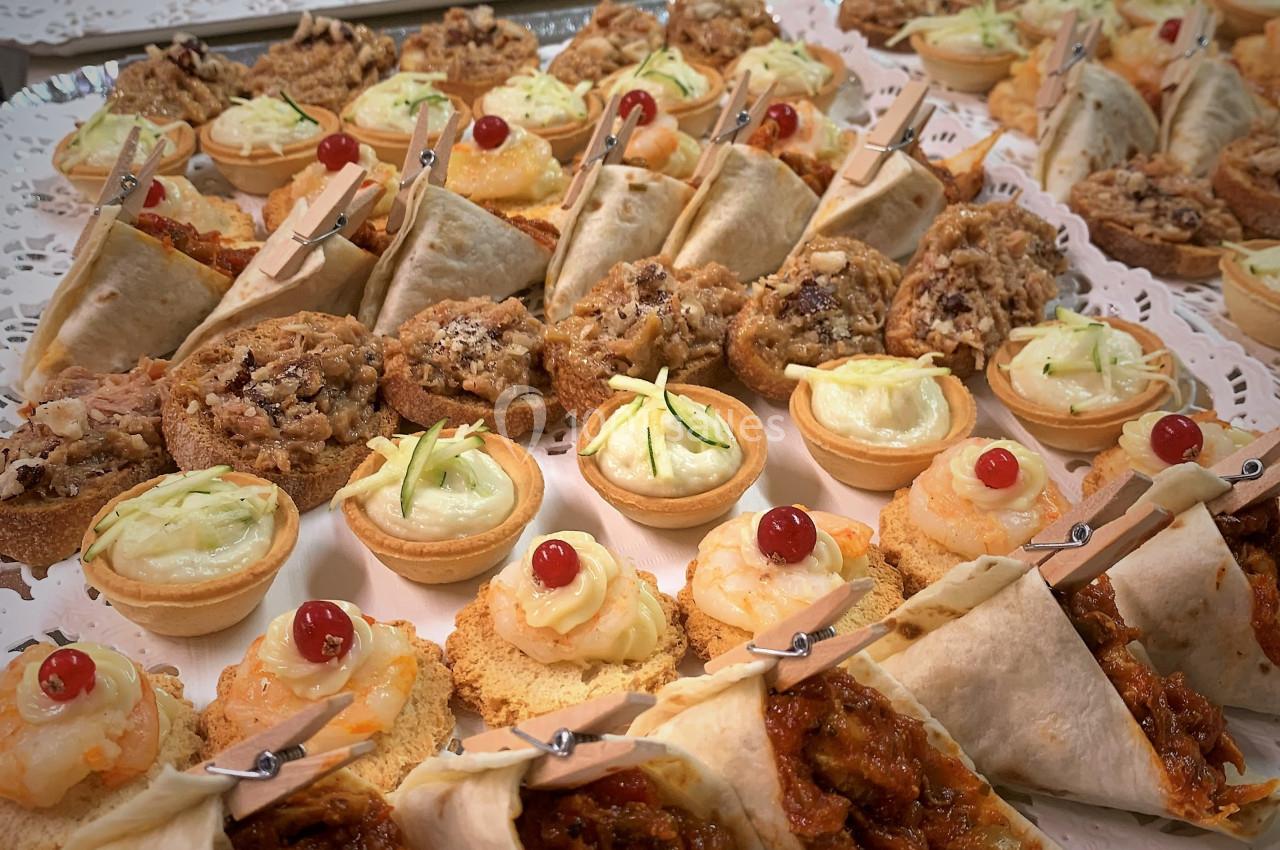Plateau de bouchées variées comprenant wraps, tartelettes salées, biscuits et amuse-bouches décorés.
