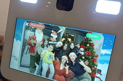 Deux femmes regardent un écran d'une borne photo rétro dans un espace décoré pour la Saint-Patrick.