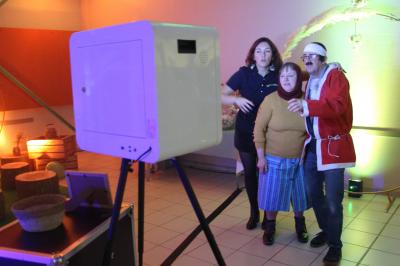 Deux femmes regardent un écran d'une borne photo rétro dans un espace décoré pour la Saint-Patrick.