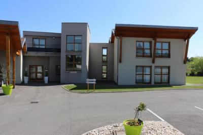 Miniature entrée de l'établissement Salle de restaurant lumineuse avec tables dressées, nappes blanches, chaises noires et grandes fenêtres donnant sur l…