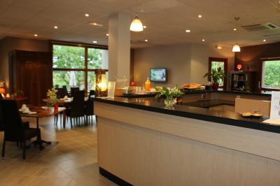 Miniature réception - bar Salle de restaurant lumineuse avec tables dressées, nappes blanches, chaises noires et grandes fenêtres donnant sur l…