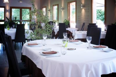 Miniature salle principale Salle de restaurant lumineuse avec tables dressées, nappes blanches, chaises noires et grandes fenêtres donnant sur l…