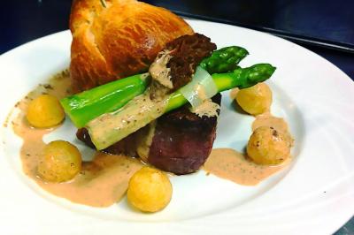 Miniature Traiteur Gagny (Seine-Saint-Denis) - J&J Traiteur Événementiel #2 Des personnes préparent et disposent des desserts sur des assiettes alignées dans une cuisine professionnelle.