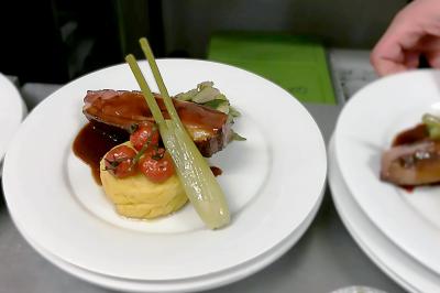 Miniature Traiteur Gagny (Seine-Saint-Denis) - J&J Traiteur Événementiel #3 Des personnes préparent et disposent des desserts sur des assiettes alignées dans une cuisine professionnelle.