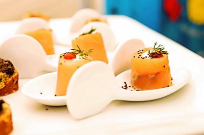 Miniature Traiteur Gagny (Seine-Saint-Denis) - J&J Traiteur Événementiel #16 Des personnes préparent et disposent des desserts sur des assiettes alignées dans une cuisine professionnelle.