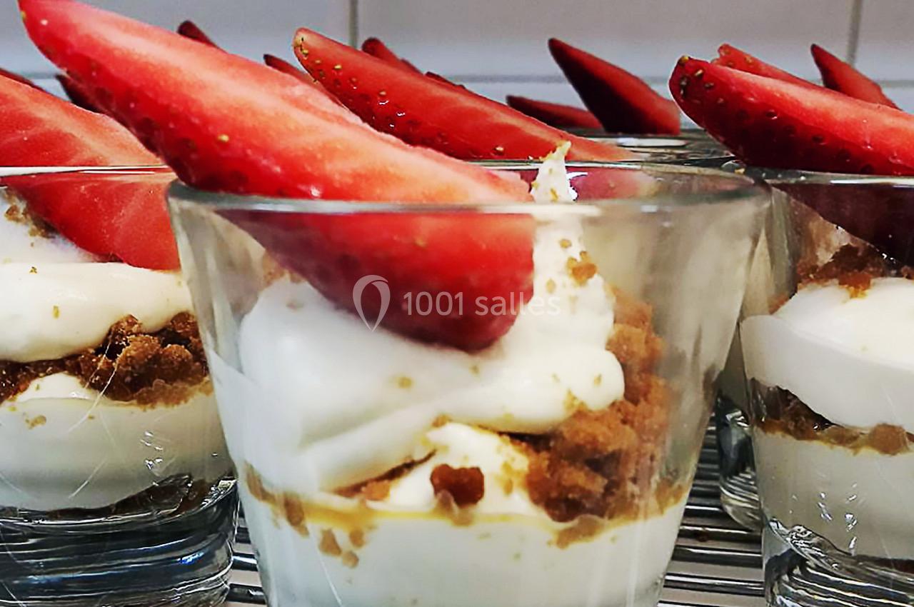 Verrines de dessert composées de crème blanche, miettes de biscuit et quartiers de fraises fraîches.