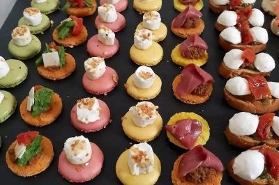 Des personnes préparent et dressent des assiettes avec des desserts dans une cuisine professionnelle.