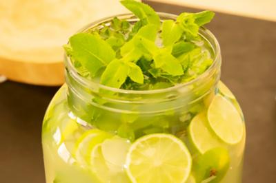 Des personnes préparent et dressent des assiettes avec des desserts dans une cuisine professionnelle.